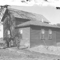 View of three people standing in front of a house