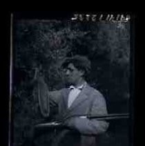 Young man holding a dead squirrel and shotgun