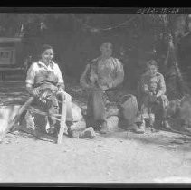 Man, woman, boy and dog sitting on rocks