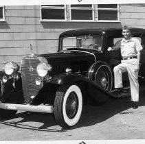 Airman standing next to vintage auto, may be Rolls Royce