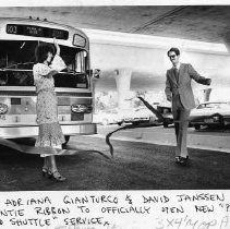 Caption reads: " Caltrans boss, Adriana Gianturco and General Services' David Janssen untie ribbon to officially open new 'Park and Shuttle' service to state buildings."