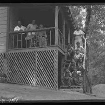 Group of people on the porch of a cabin