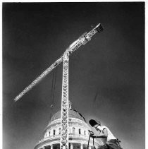 View of a worker on the scaffolding at the California State Capitol building restoration project with the crane above