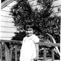 Young girl standing at a fence
