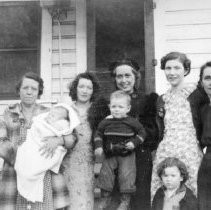 Five women and three children on the porch of a home