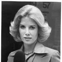 Joan Lunden, holding a microphone, upper body