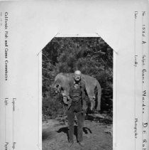 Photographs from Wild Legacy Book. "Game Warden D.E. Roberts" with a mountain lion over his shoulders