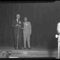 Two unidentified men on a stage