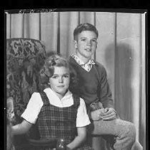 A boy and girl sitting on a chair