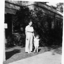 Woman and girl standing in front of house