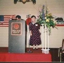 Banquet Reception: Unidentified Speaker at Podium with Woman