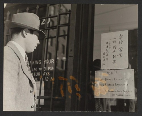 [Man reading sign, 'Our business licence has been revoked temporarily - The Yokohama Specie Bank, LTD; Los Angeles, California]