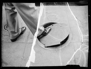 Manhole on sidewalk in front of O.T. Johnson building, O.T. Johnson Corporation, assured, Southern California, 1936