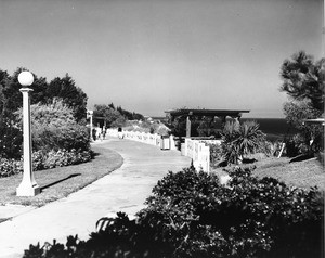 A walkway in a park overlooking the ocean