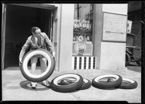 Mr. Price throwing tires over city hall and stack of tires, Los Angeles, CA, 1931