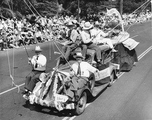 Fishers from Wisconsin dangle fishing line from a car as they drive in the American Legion Parade