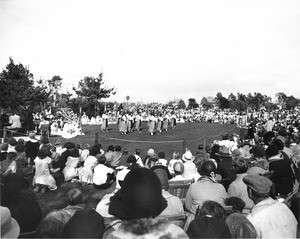 A dance troupe performs for a large crowd in the middle of Exposition Park