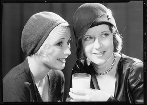 Two girls talking at table & glass of milk, Fresh Milk Industries, Southern California, 1931