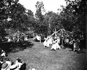 A bunch of people perform a ceremony at one of Los Angeles' many parks, as many citizens watch the performance