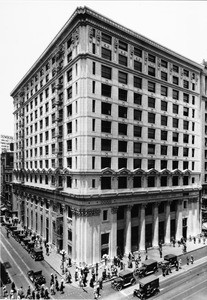 A high-angle view of the Pacific Southwest Trust and Savings Bank as people crowd along the sidewalk, Los Angeles, ca.1936-1940