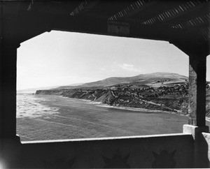 A view of the coast with scattered houses on the hills above the ocean