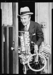 Father sneaking in with Christmas gifts, Southern California, 1932