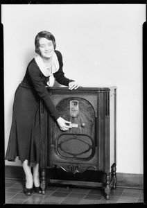 Girl putting plates on radio, Southern California, 1930