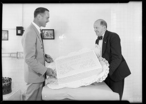 Mr. Eckendoll of Swift & Co. presenting manager of Ralph's Grocery Store a cake, Southern California, 1931