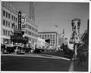 Looking east from the corner of Hollywood Boulevard and Wilcox Avenue, with the Warner Brothers Hollywood Theatre advertising "The Dawn Patrol" with Errol Flynn, and "Nancy Drew Detective", ca. 1938-1939