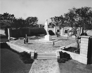 People stare up at a giant sculpture of David inside a courtyard at the Forest Lawn Memorial Park