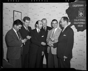 L.J. Roberts presenting key rings to group of men, Southern California, 1940