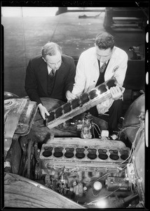 Examining motor of 60,000 mile Studebaker, Southern California, 1934