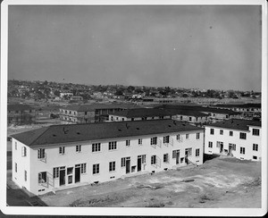 Wyvernwood Housing complex with 2-story units divided by greenbelt and walkways under construction