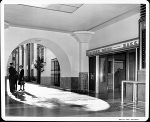 A woman speaks with a porter outside the baggage waiting room at Union Station