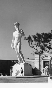 Two kids looking up at a sculpture of David at the Forest Lawn Memorial Park