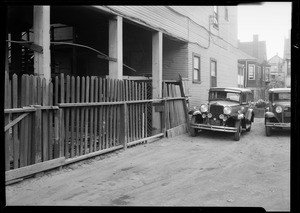 Hole in fence rear of Cumbert and hotel, Southern California, 1931