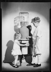 Children and water bottle in studio, Southern California, 1929