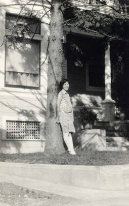 Photo of a Chinese American woman pose in the front yard of house
