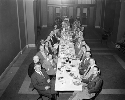 Men seated at long dining table