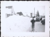 Boy posing next to giant snow mound