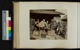 Scene of laborers surrounding a mortar and pestal