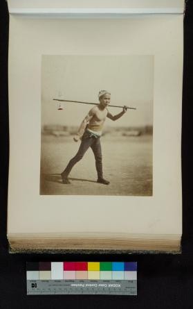 Portrait of a man walking with a pole over his shoulder