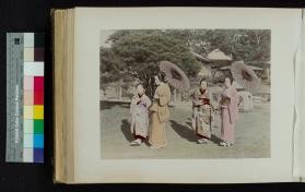 Photograph of young women walking and holding hands in a garden