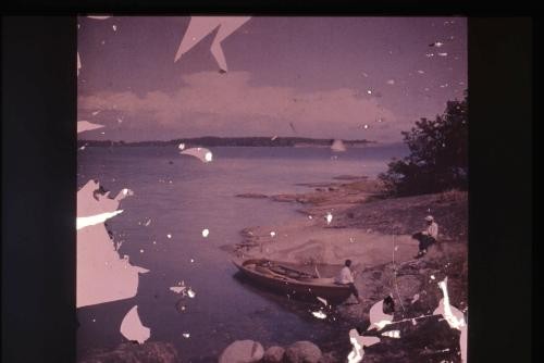 Photograph of two people in distance along shore of lake