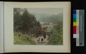Photograph of child and adults by a torii in a forest