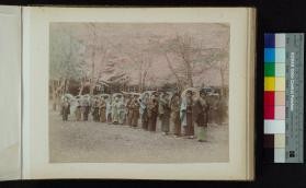 Photograph of girls lined up under cherry blossom trees