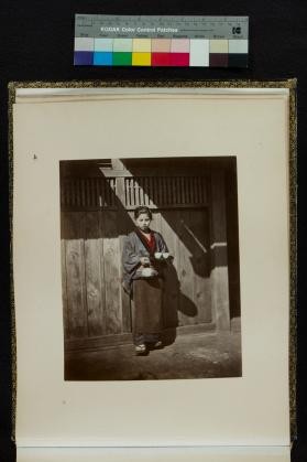 Portrait of young woman holding tea set
