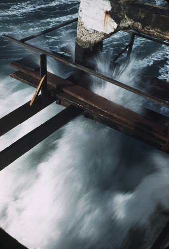 Breaking wave striking the original wooden Scripps Pier