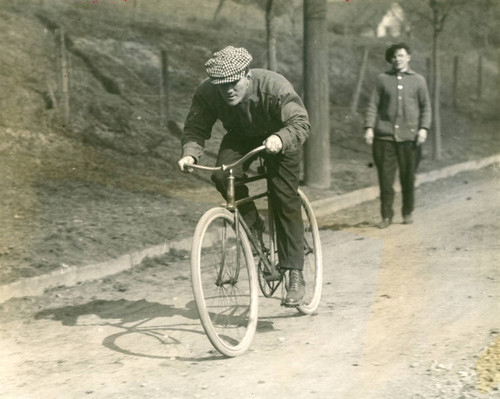 Two boxers associated with Billy Shannon, one riding bicycle, San Rafael, California, circa 1910 [photograph]