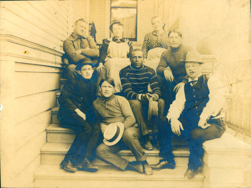 A group of boxers, and others, including Billy Shannon, seated on the steps of his house. San Rafael, California, 1908 [photograph]